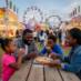 Family enjoying funnel cakes at carnival