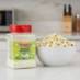 Snappy Ranch Popcorn Seasoning next to a bowl of popcorn