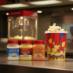 Snappy White Cheddar, Cheddar and Theater Salt next to a tub of popcorn at a theater