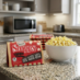 Snappy Movie Theater Butter microwave popcorn ready to be popped next to a bowl of popcorn